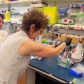 Researcher showing visitor how to use lab equipment