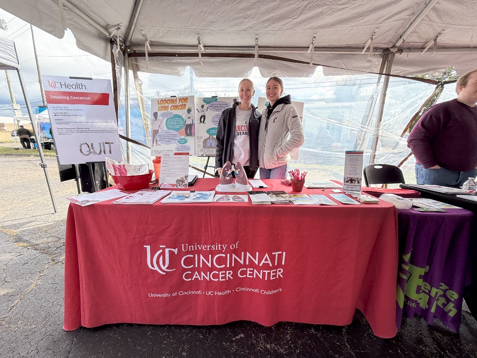 Red Cancer Center booth with two volunteers smiling at Awareness day in Avondale