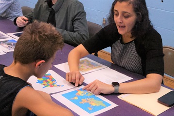 Cancer Center doctor teaches child geography during basketball program