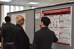 two people talking by an academic poster