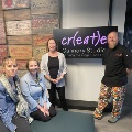 a group of people in front of the create culinary studio sign