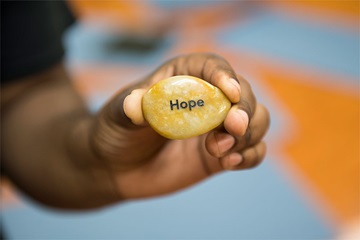 hand holding stone with the word hope