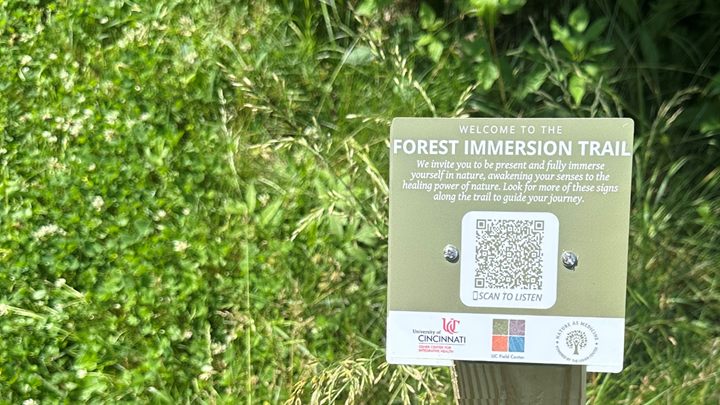 A sign for the forest immersion trail surrounded by greenery
