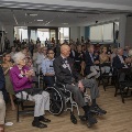 A room full of seated guests clapping their hands