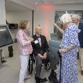 Three people talking with others in background
