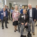 A seated man poses with other guests