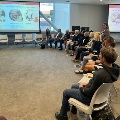 Group of people on chairs watch presentation