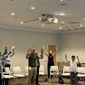 Several of people doing tai chi with arms up