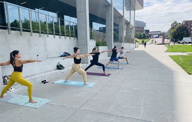 Group of students practicing yoga outdoors at the university of cincinnati